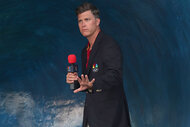 Colin Jost pretends to surf at the 2024 Olympics