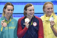 Katie Ledecky, Sarah Sjostrom, and Emma McKeon hold up their medals.