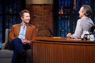 Glen Powell smiles at Seth Meyers during an interview