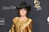 Shania Twain wears a gold outfit and black cowboy hat on the red carpet