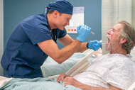 Dr Bruce looks inside a patients mouth on the pilot episode of st. denis medical