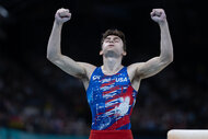 Stephen Nedoroscik holds his arms up celebrating at the 2024 Olympics