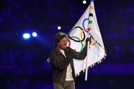 Tom Cruise holds the Olympic flag at the Closing Ceremony in Paris