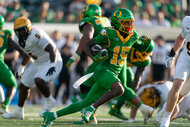 Tez Johnson of the Oregon Ducks running with a football during a game.