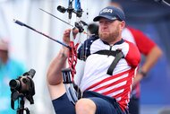 Matt Stutzman shoots a bow and arrow with his feet at the 2024 Paralympic Games.