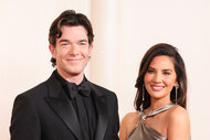 John Mulaney and Olivia Munn smile together on the red carpet