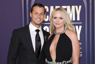 Miranda Lambert in a black dress stands with her husband Brendan Mcloughlin at the Academy of Country Music Awards