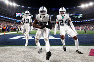 Some of the Dallas Cowboys celebrate at the end zone during a football game