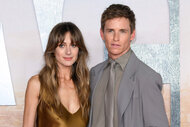 Hannah Bagshawe wears a brown silk dress next to Eddie Redmayne