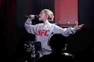 Ariana Grande in a UFC sweatshirt singing