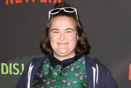 Betsy Sodaro wears glasses on top of her head and smiles on the red carpet