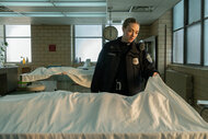 Mickey holds a sheet over a body in Long Bright River Season 1, Episode 1.