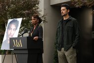 Gabi (Shanola Hampton) delivers a speech at a podium next to Dahn (Karan Oberoi) and a photo of a man.