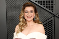 Kelly Clarkson smiles in a white gown.