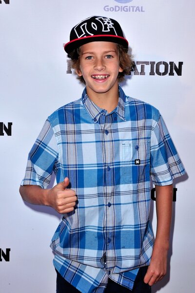 Jagger Eaton holds a thumbs up in a blue plaid shirt.