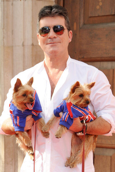 Simon Cowell holds his 2 Dogs