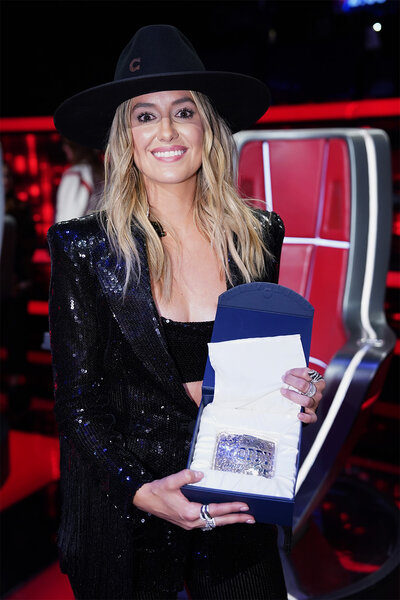 Lainey Wilson holds a belt buckle on the voice finale part 2