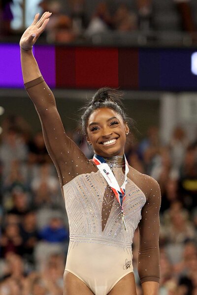 Simone Biles waves to the crowd during the medal ceremony