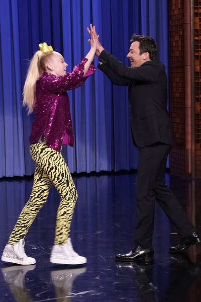 JJojo Siwa and Jimmy Fallon high five after dancing on the tonight show starring jimmy fallon