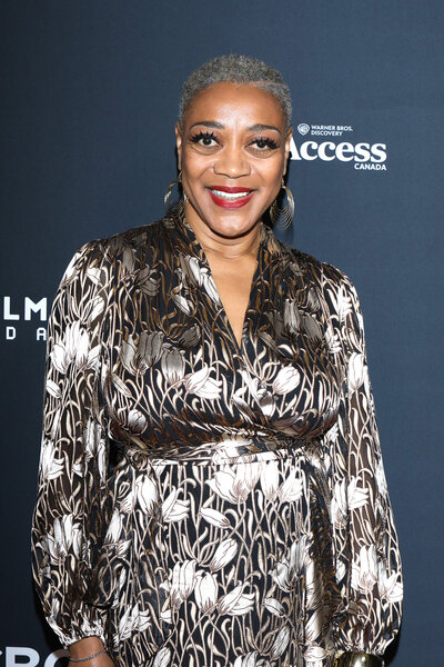 Karen Robinson smiling in front of a step and repeat.