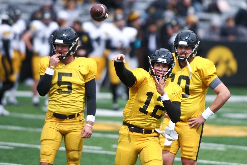 Iowa Hawkeyes football team throwing a pass.