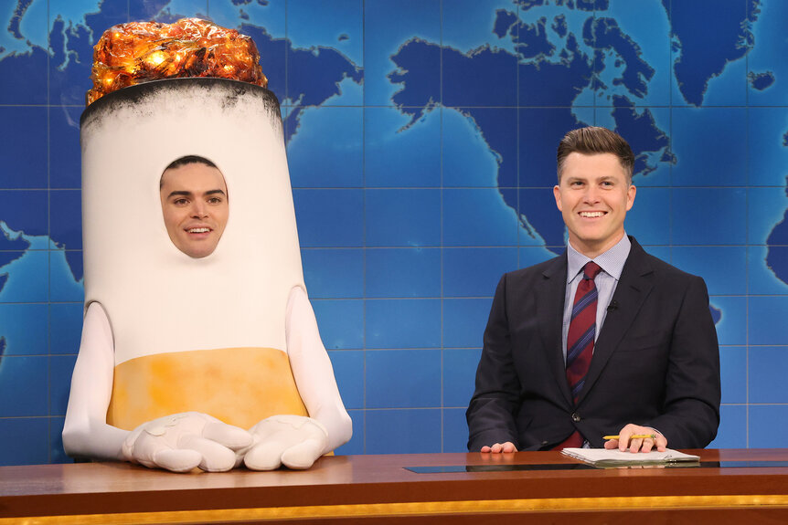 Michael Longfellow dressed as a cigarette and colin jost during the weekend update on Saturday night live episode 1850