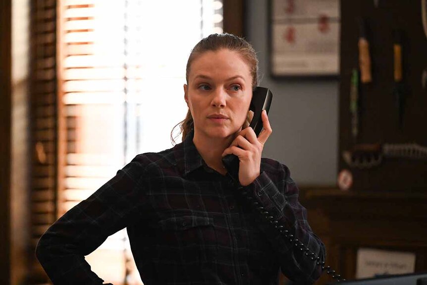 Hailey Upton wears all black and speaks on a telephone in Chicago P.D. Episode 1102