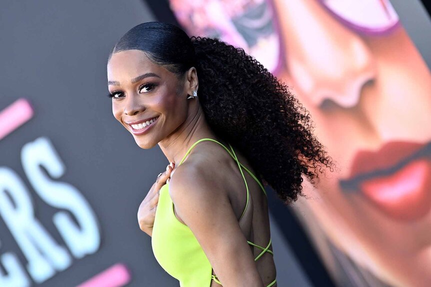 Zuri Hall smiles in a neon yellow dress.