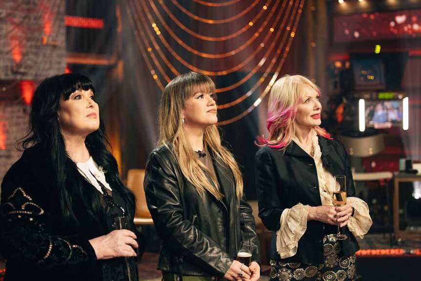Ann Wilson, Nancy Wilson, and Kelly Clarkson look into the distance on The Kelly Clarkson Show Episode 7I121.