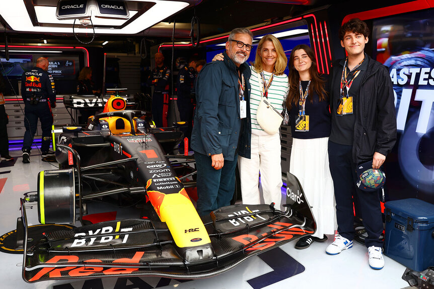 Steve Carell, Nancy Carell, Annie Carell and Johnny Carell pose for a photo with the car of Max Verstappen of the Netherlands and Oracle Red Bull Racing