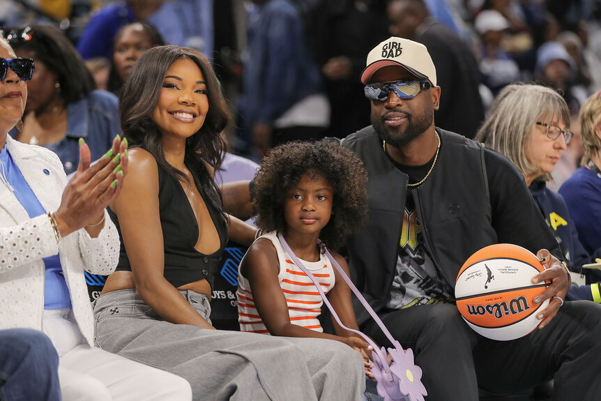 Gabrielle Union, Kaavia Wade, and Dwyane Wade pose for a photo during the first half of a WNBA game
