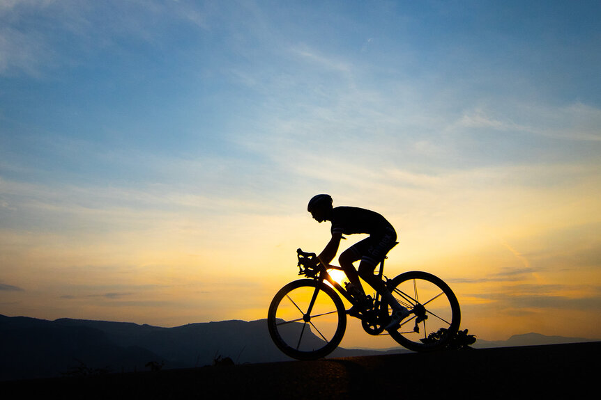 Yareli Salazar cycling in front of a sunset.