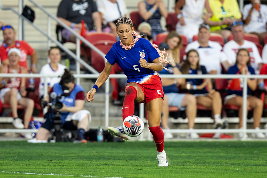 Trinity Rodman kicks a soccer ball during a game on the field