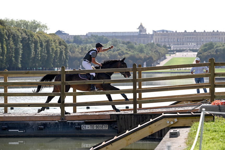 A competitor on their horse at the 2024 Olympics in front of Versailles