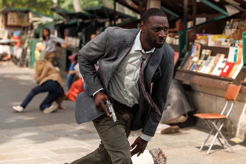 Sey (Omar Sy) runs with a weapon in The Killer (2024).