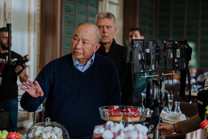 Director John Woo speaks to crew on the set of The Killer (2024).