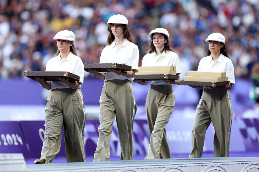 Staff from the Olympics hold boxes to pass out during the medal ceremony