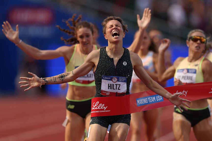 Nikki Hiltz smiles with her arms outstretched.