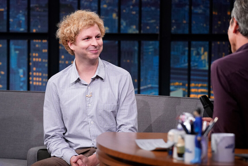 Michael Cera smiles during an interview with Seth Meyers