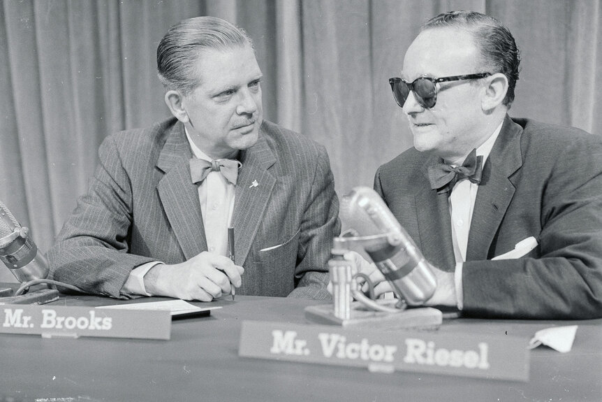 Victor Riesel (R) blinded by an acid attack two months prior, talks with moderator Ned Brook