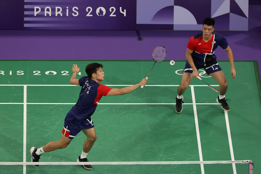 Vinson Chiu and Joshua Yuan of Team United States play a shot against Team Japan during a Men's Doubles badminton match