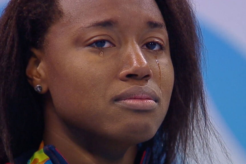 Gold medalist Simone Manuel of the United States becomes emotional on the podium during the medal ceremony for the Women's 100m Freestyle Final on Day 6 of the Rio 2016 Olympic Games