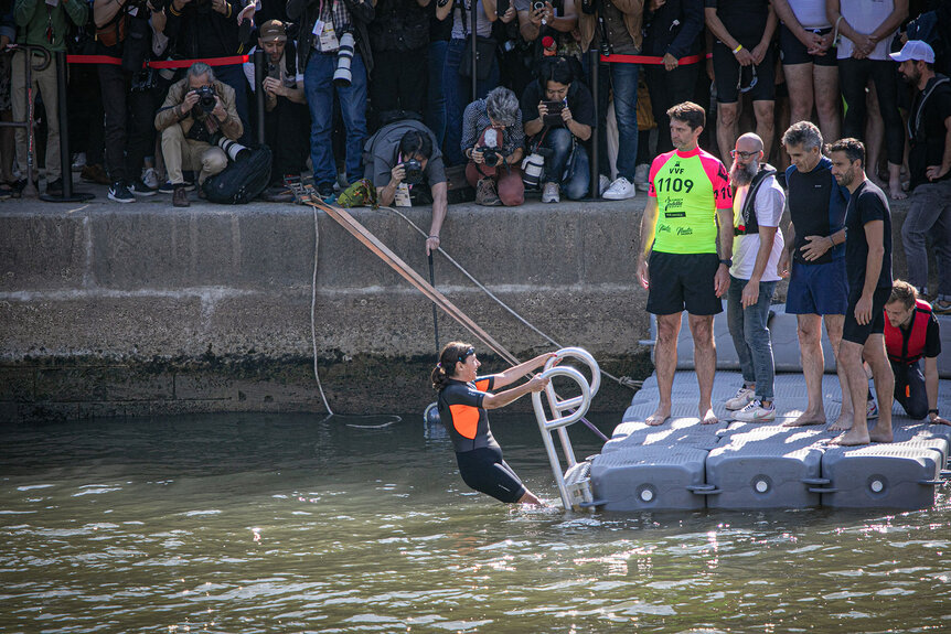 Anne Hidalgo climbing a ladder after swimming in the Seine river.