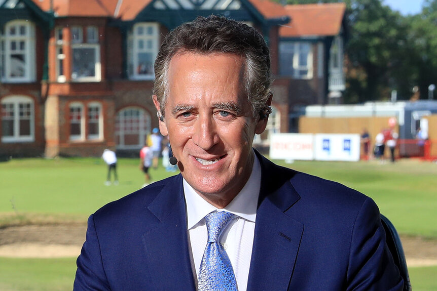 Rich Lerner wears a blue suit while commentating at a golf course