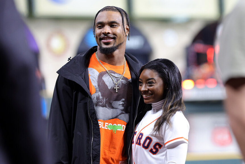 Simone Biles and Jonathan Owens pose on the field prior to Game One of the 2022 World Series