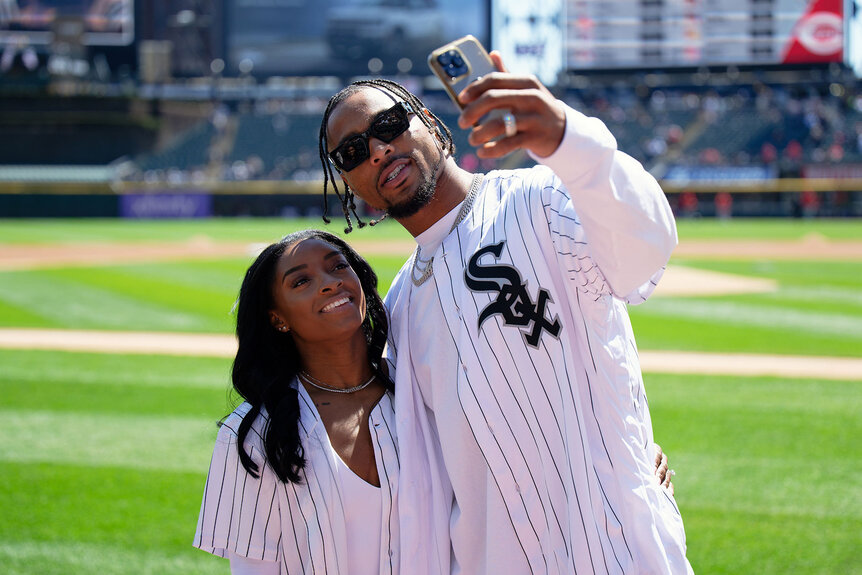 Simone Biles and Jonathan Owens of the Chicago Bears record a video on the field before Owens threw out a first pitch at a White Sox game