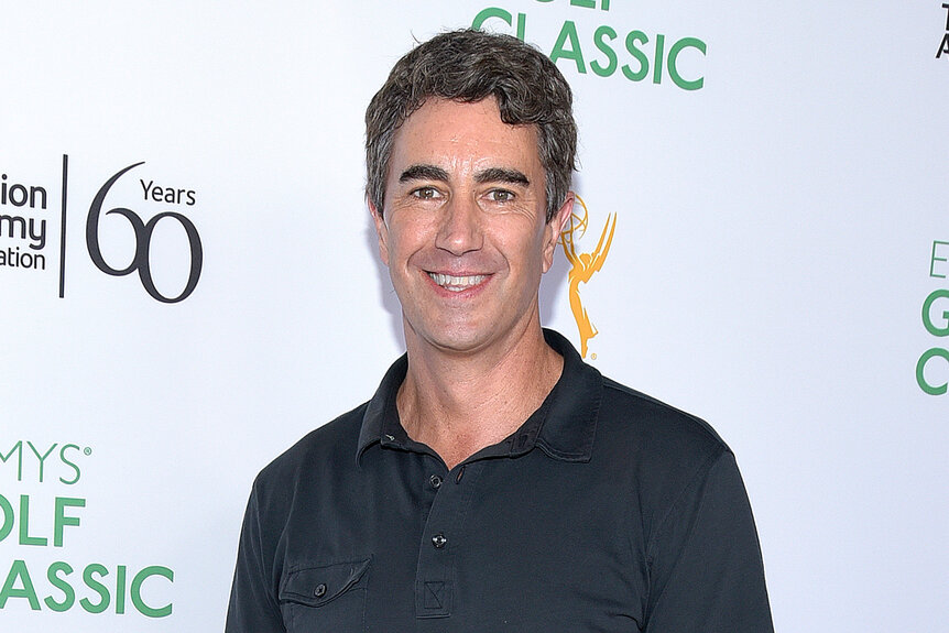 Terry Gannon smiles in a blue polo at an event for the emmys golf classic