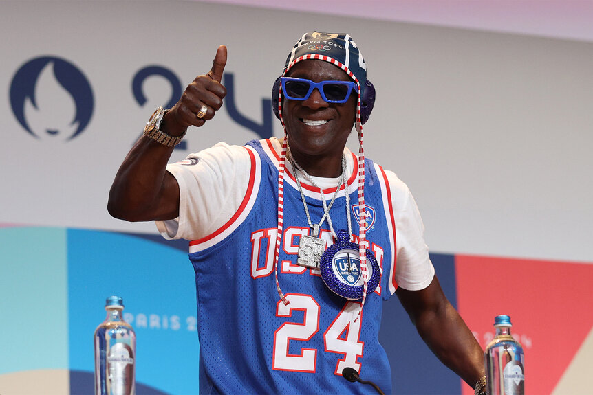 Flavor Flav gives a thumbs up and smiles at the 2024 Olympics during a press conference