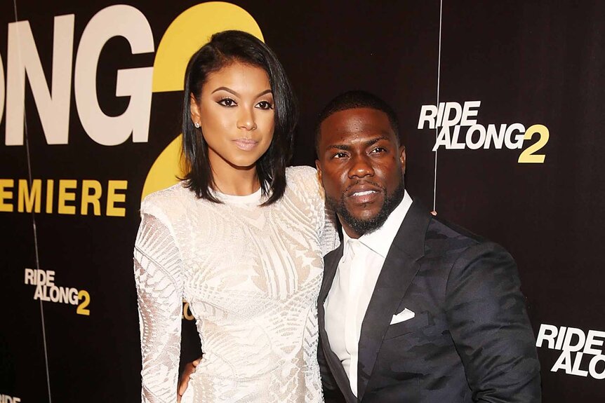 Eniko Parrish and Kevin Hart smile together at a premiere.