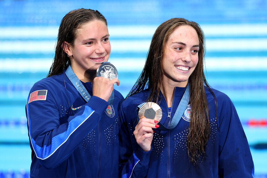 Katie Grimes and Emma Weyant hold up their medals at the 2024 olympics